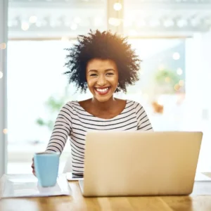 smiling lady at laptop with mug starting her own business