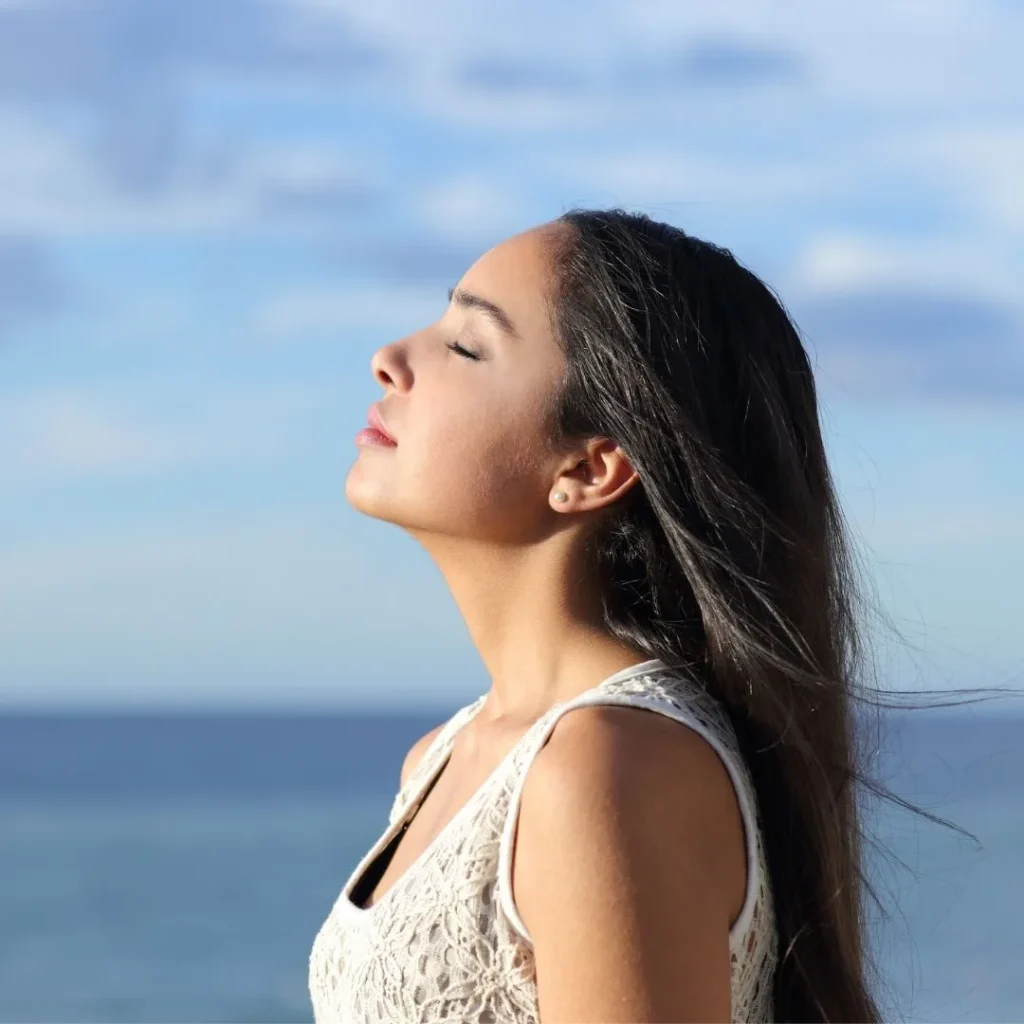 Woman seen breathing with sky and water background
